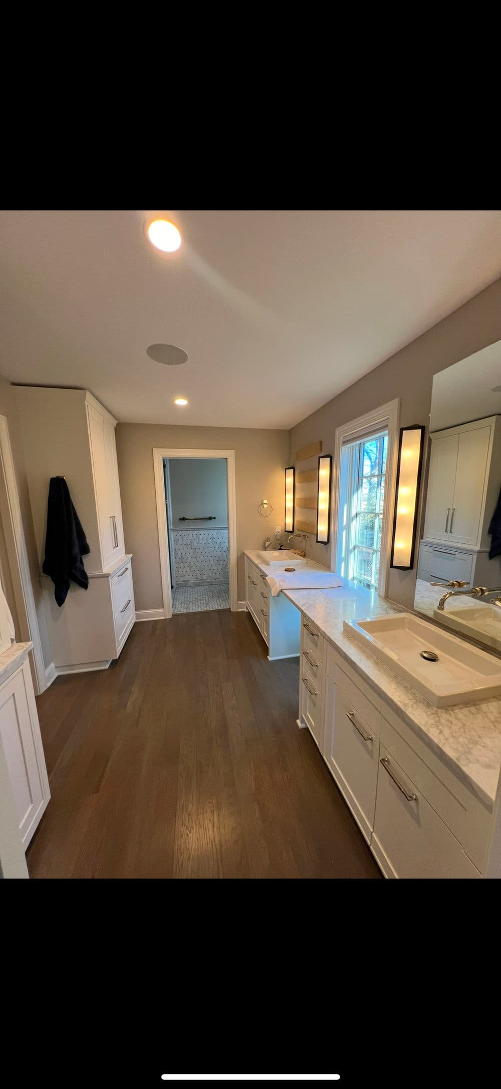 Modern bathroom with double sinks, marble countertop, and natural light. Elegant design and spacious layout.