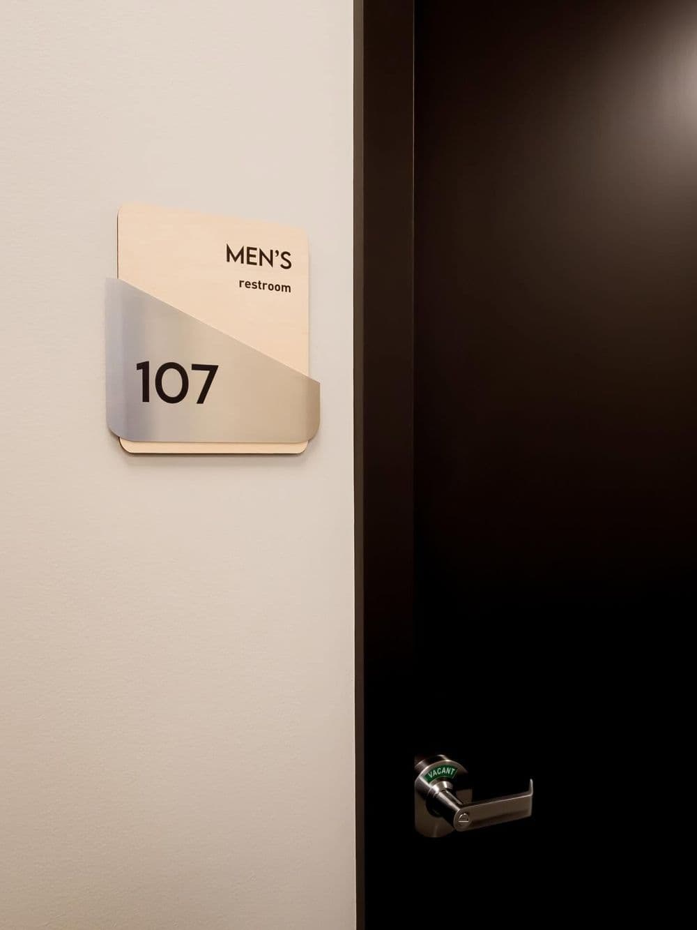 Men's restroom sign on door with room number 107, modern design.