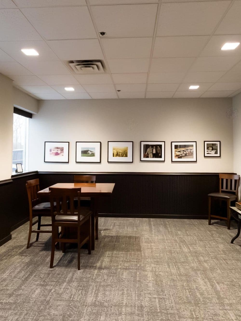 Cozy dining area featuring a table, chairs, and framed photos on the wall.